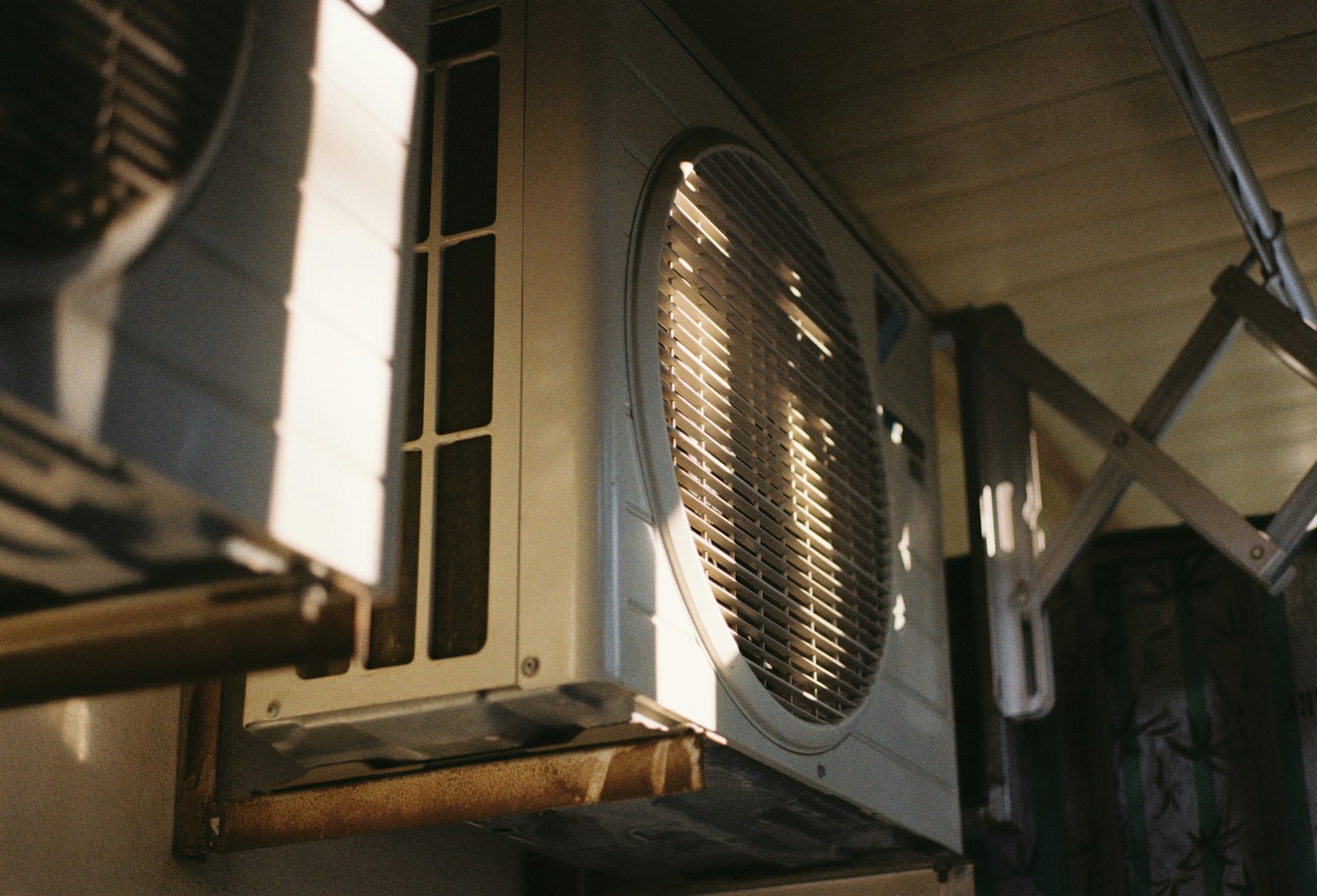 An outdoor air-conditioning condenser mounted on a wall bracket