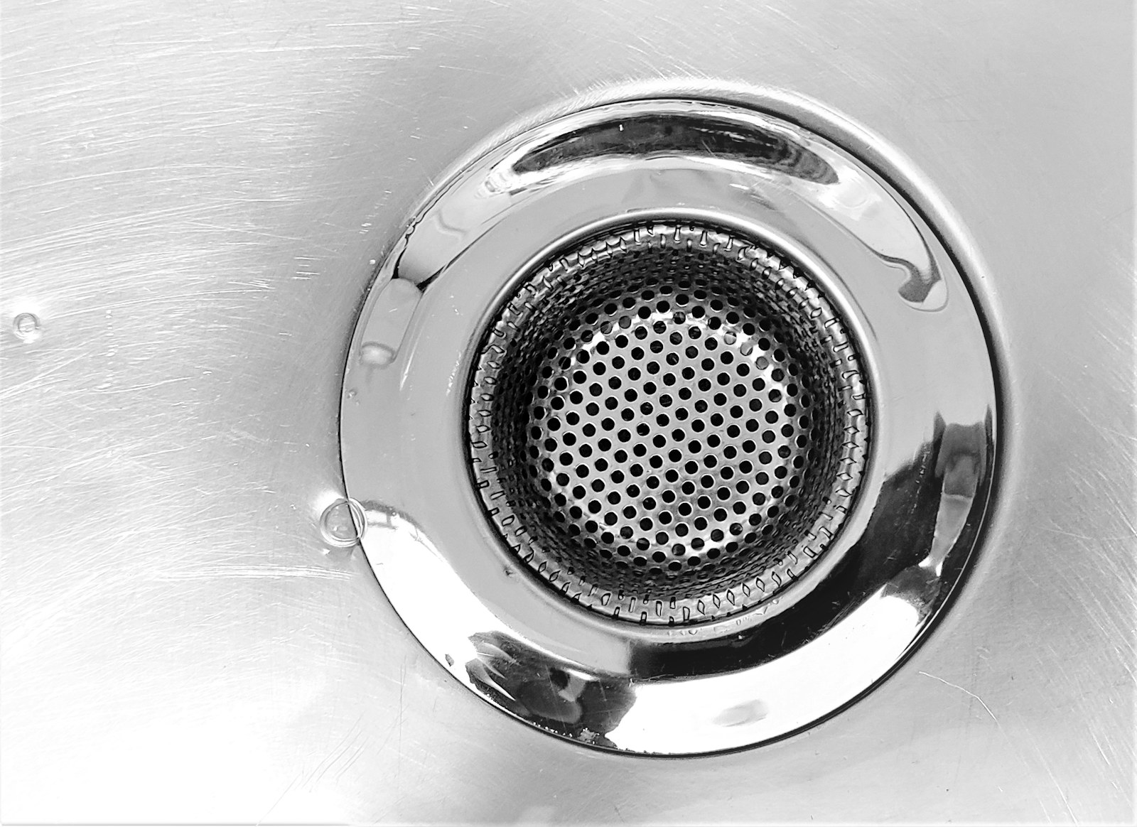 A close view of a stainless steel sink drain and removable strainer
